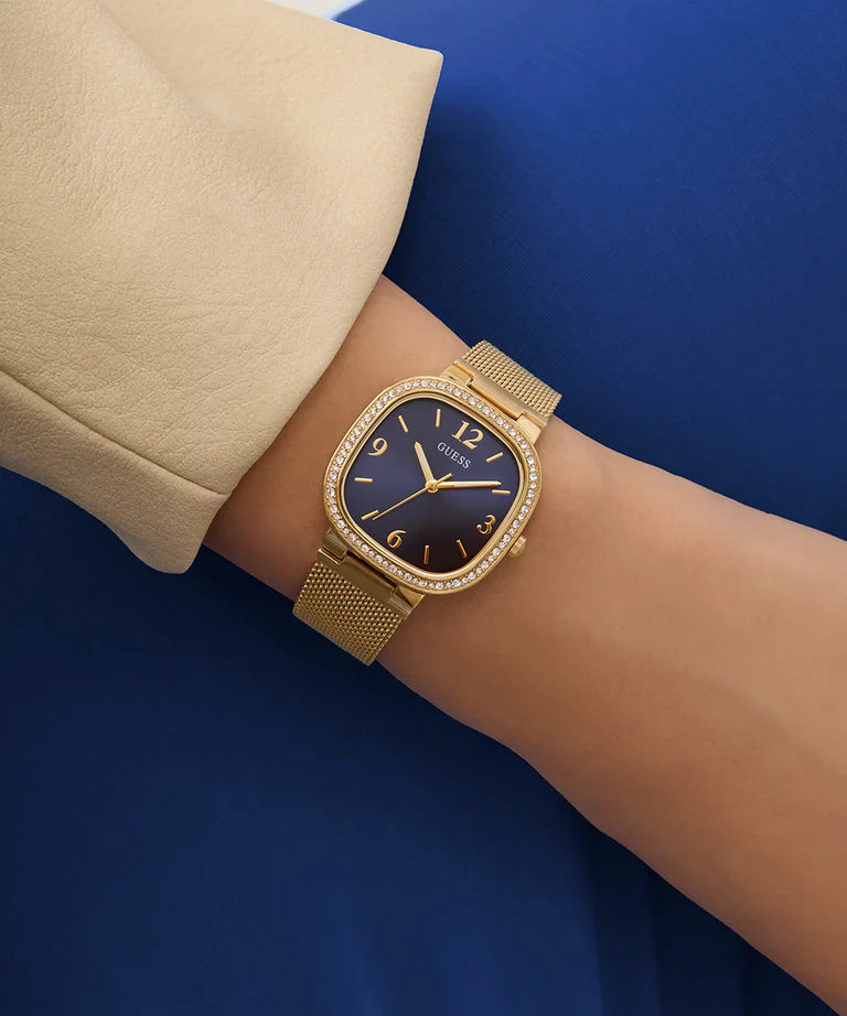 Guess Tapestry watch worn on wrist with gold mesh strap and blue dial