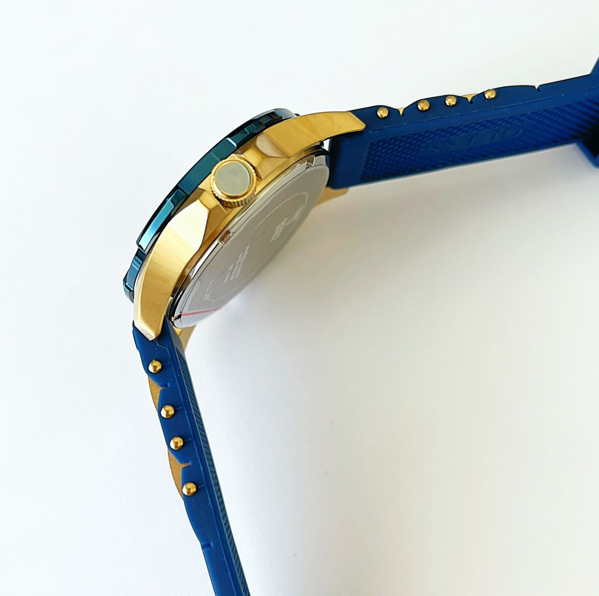 Side profile of Guess W0366G6 watch case and blue silicon strap with gold studs and accents