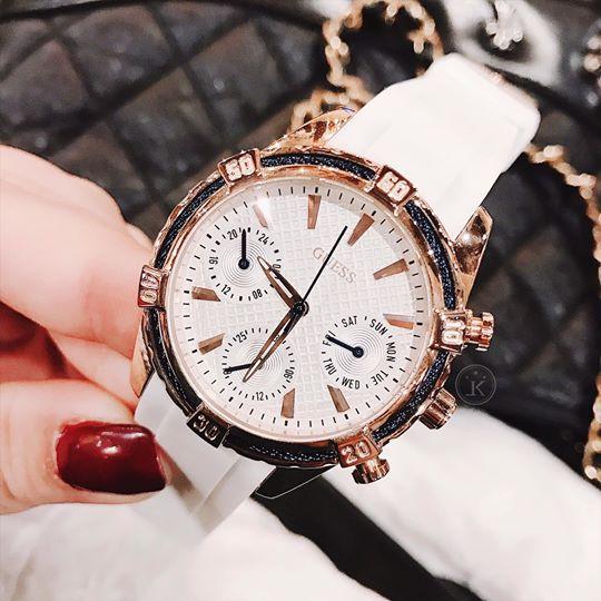Guess W0562L1 watch worn on wrist with white rubber strap and rose gold case