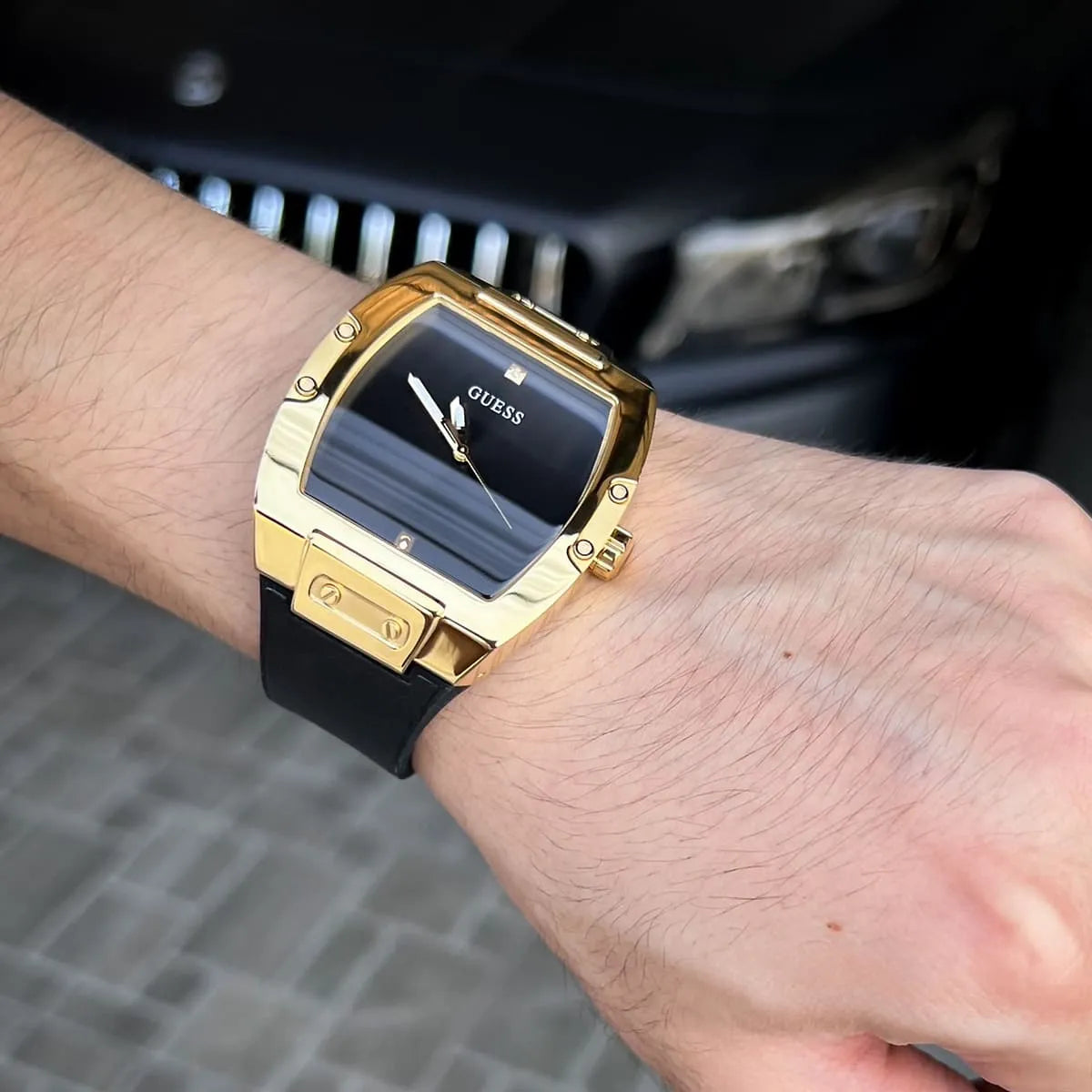 Guess Phoenix watch worn on wrist showing gold case and black leather strap