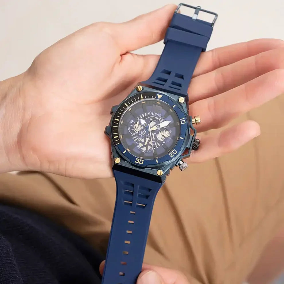 GUESS GW0443G1 blue multifunction watch held in hand showing dial and rubber strap