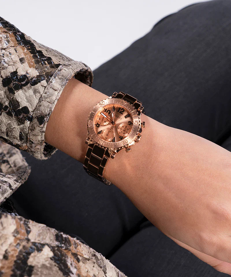 Guess Cosmic rose gold watch worn on wrist with snake print sleeve