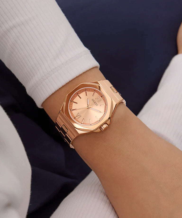Guess Empress rose gold watch worn on wrist with white and navy outfit