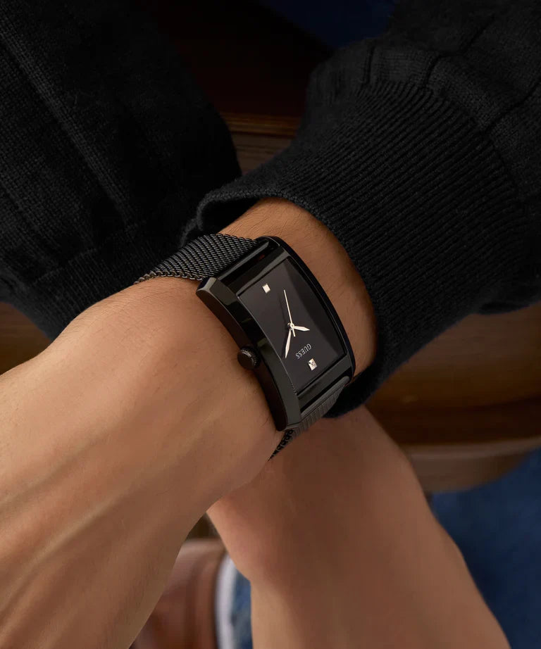 GUESS black rectangular watch on wrist styled with dark and light colored clothing