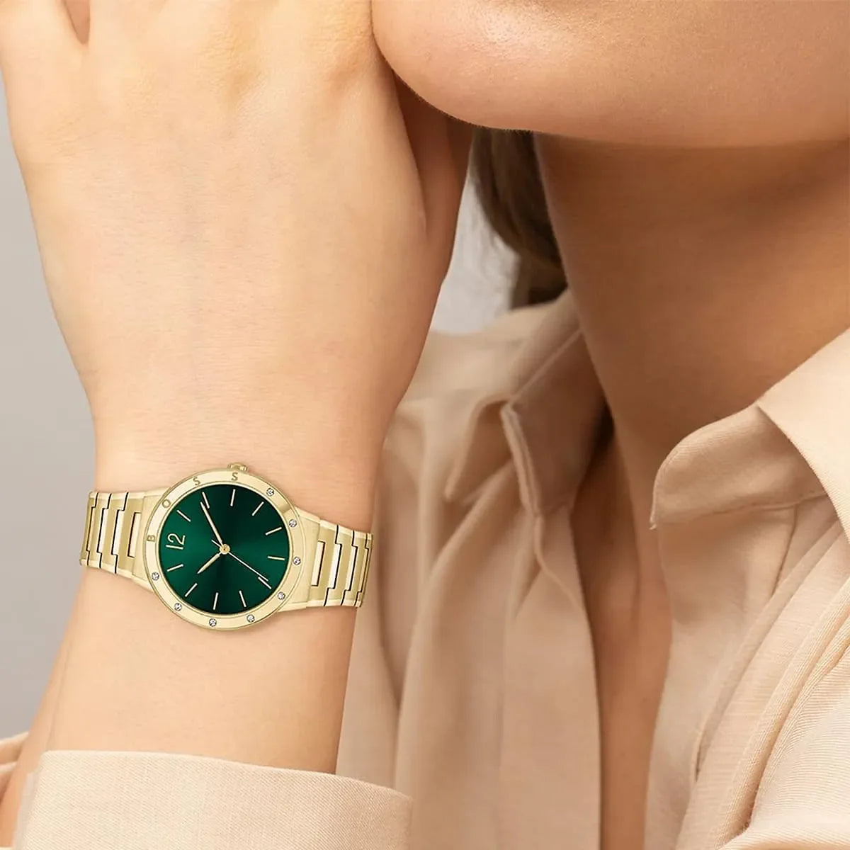 Hugo Boss gold watch with green dial worn on wrist