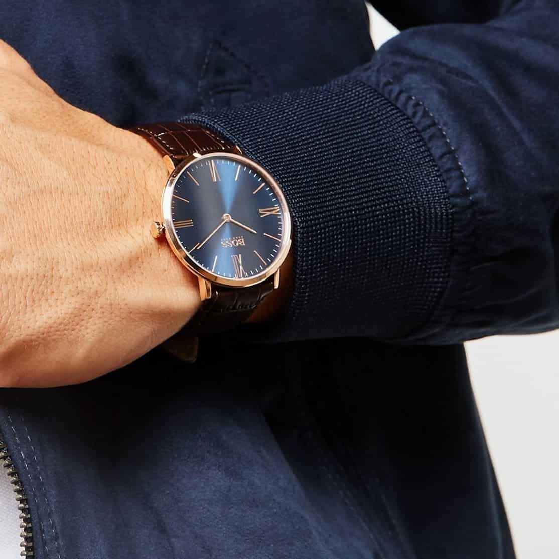 Hugo Boss men's watch on wrist showing blue dial and rose gold case with brown leather band