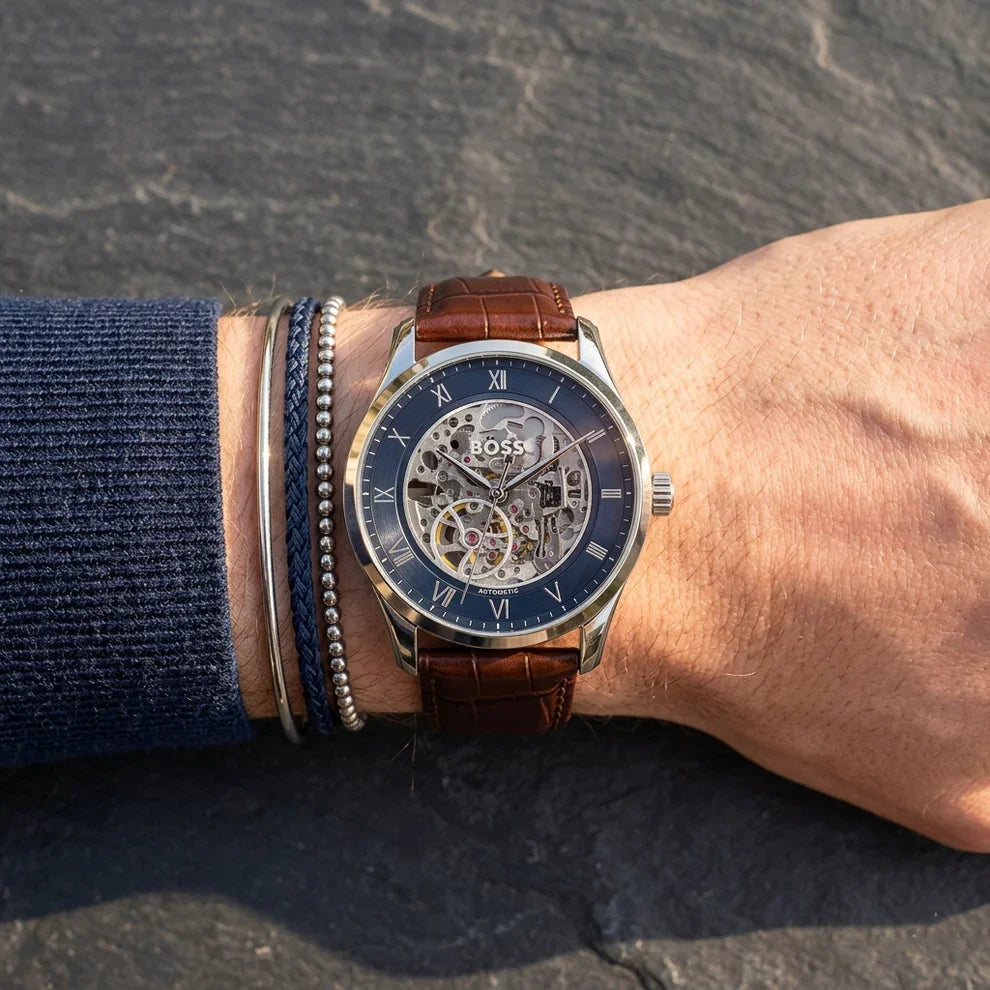 Hugo Boss skeleton watch on wrist showing navy dial with exposed automatic movement