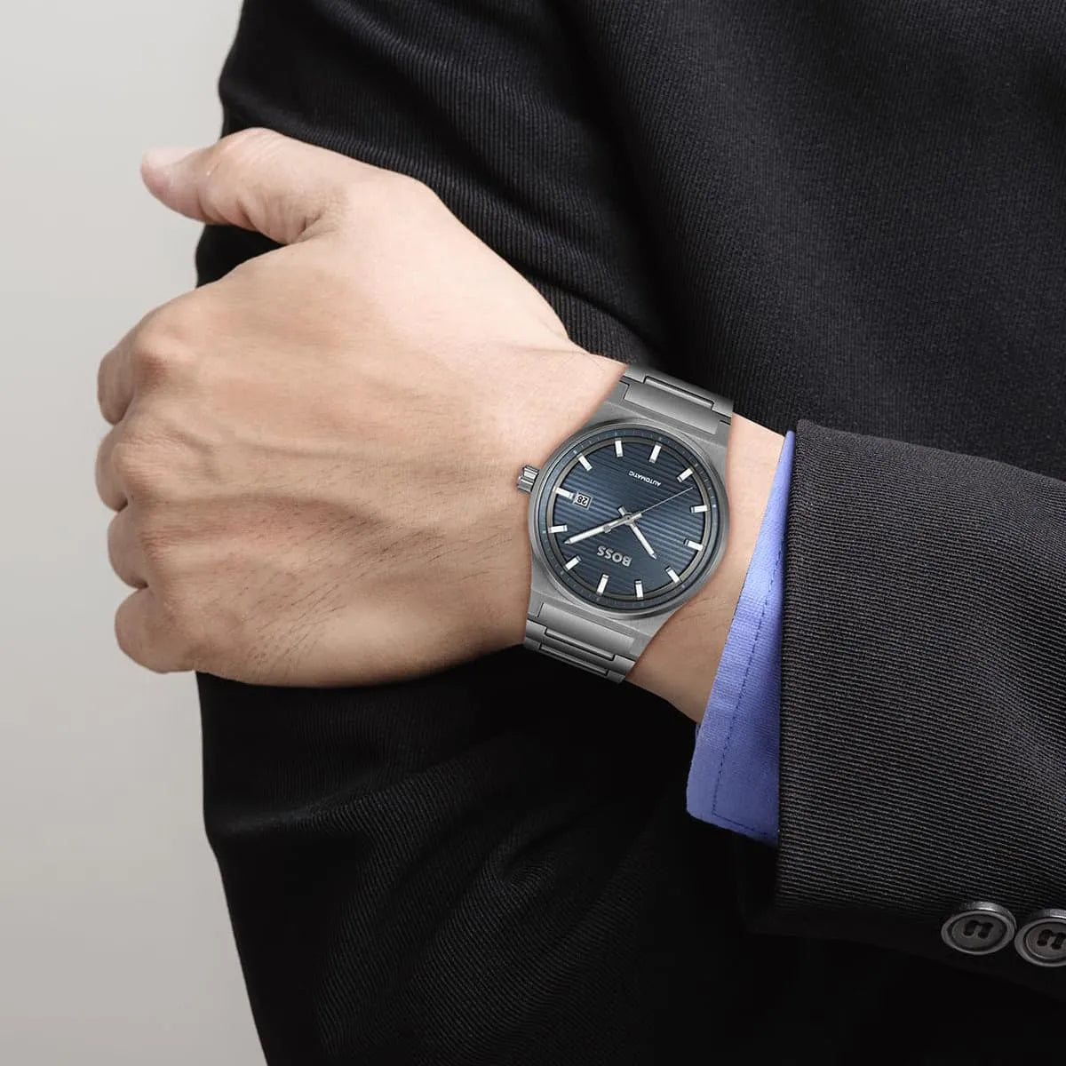 Hugo Boss Candor Auto watch on wrist, showing blue dial and gray steel bracelet in worn view