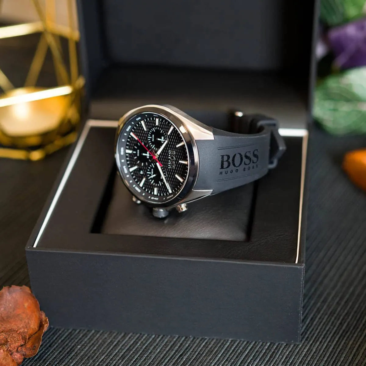 Hugo Boss Distinct chronograph watch displayed in presentation setting with black box and lifestyle accessories