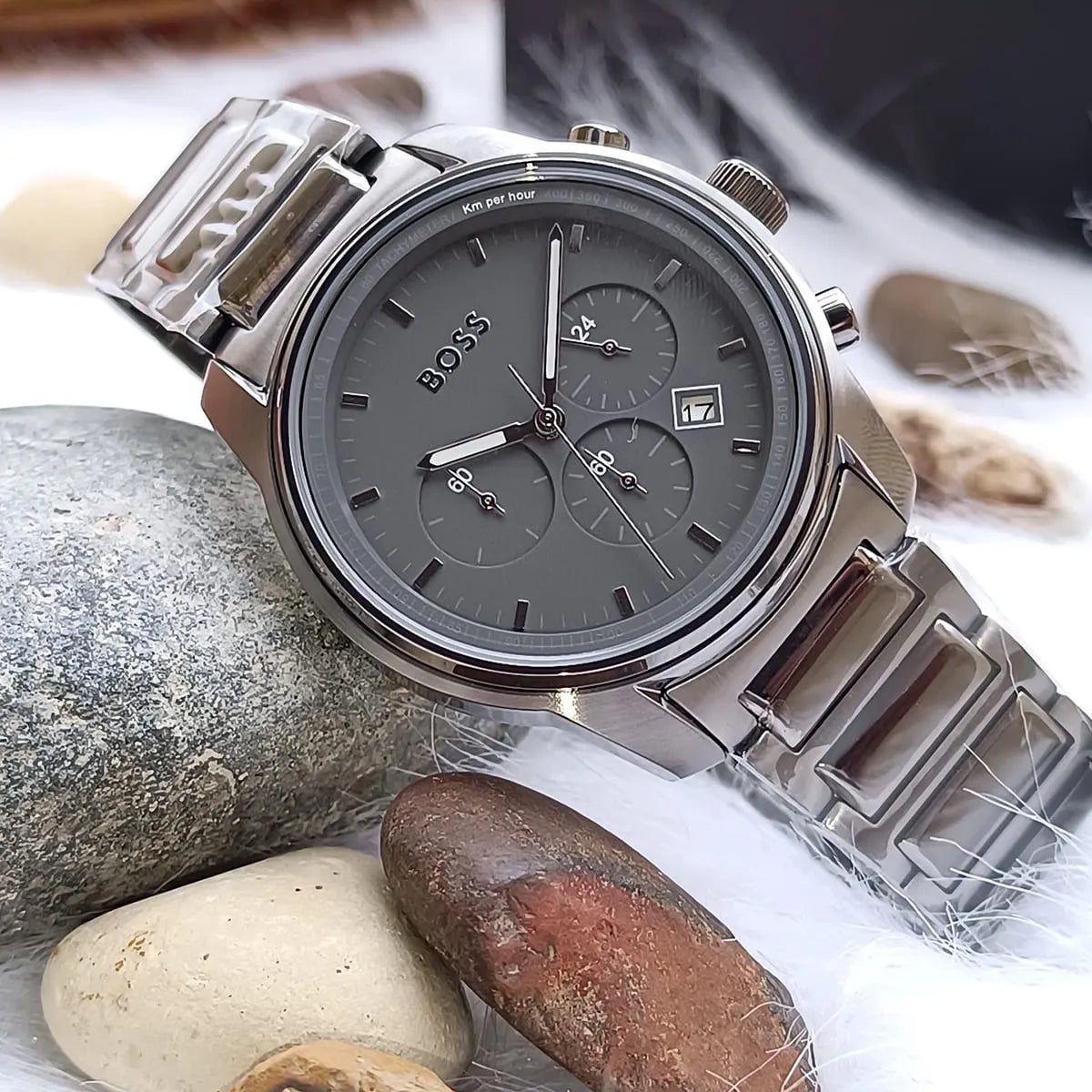 Hugo Boss Trace chronograph watch displayed on rocks with grey steel bracelet