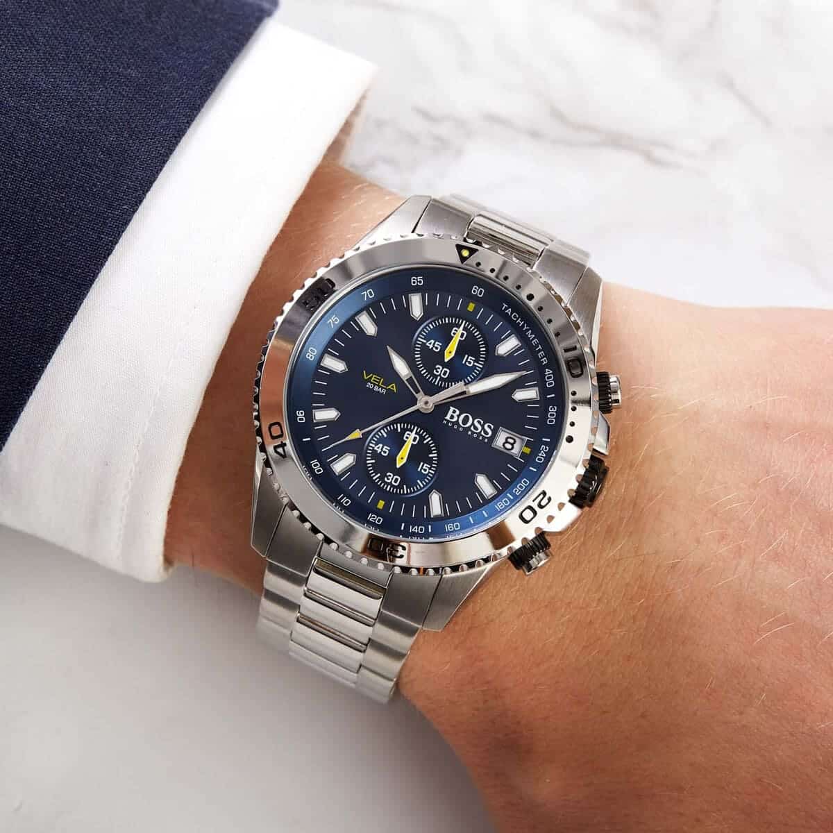 Hugo Boss Vela chronograph watch worn on wrist with blue dial and stainless steel bracelet