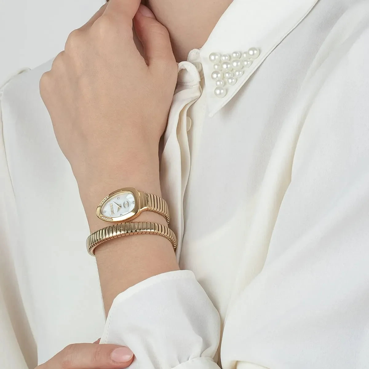 Just Cavalli snake watch worn on wrist with gold double-wrap bracelet