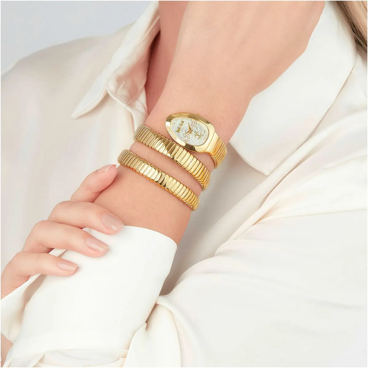 Just Cavalli Cosenza watch worn on wrist with triple-wrap gold bracelet strap