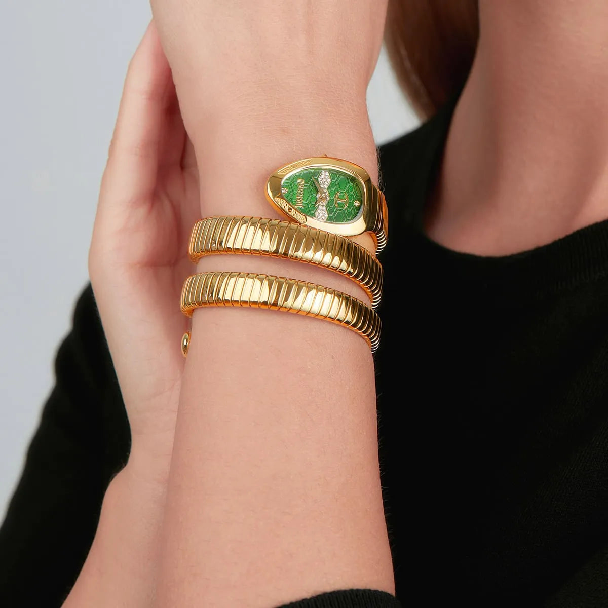 Just Cavalli Cosenza women's watch worn on wrist with gold triple-wrap snake strap