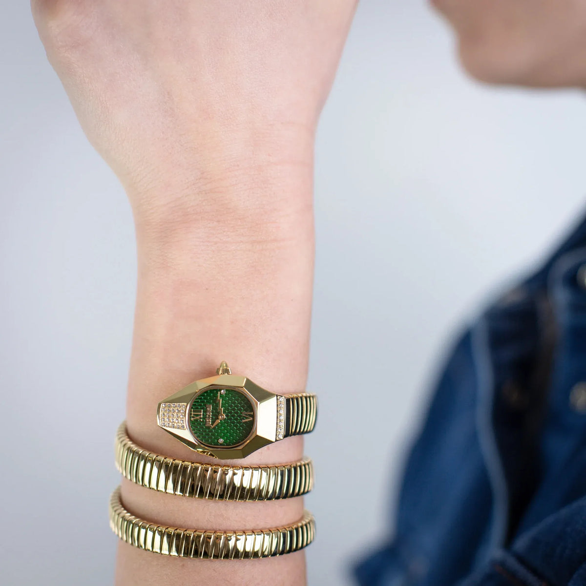 Just Cavalli Signature Snake Lunara watch worn on wrist with stacked snake-textured bracelets