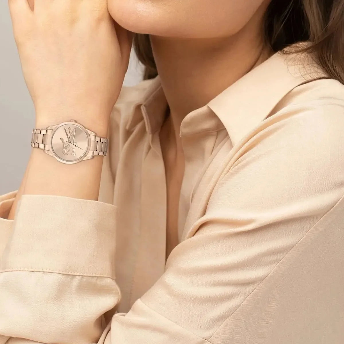 Lacoste carnation gold women's watch worn on wrist, crocodile dial design visible