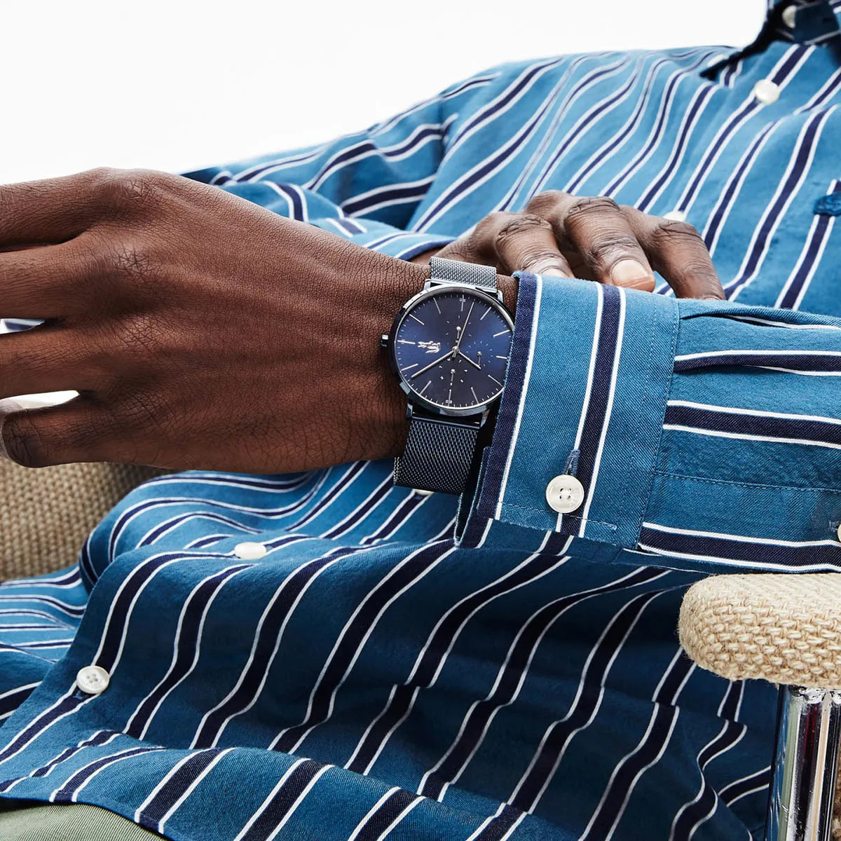 Lacoste Moon 2011058 watch worn on wrist with blue Milanese mesh strap against striped shirt