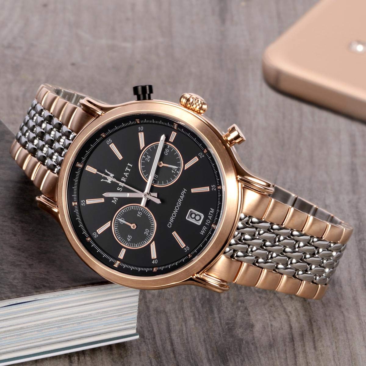 Maserati chronograph watch with black dial and two-tone bracelet displayed on surface