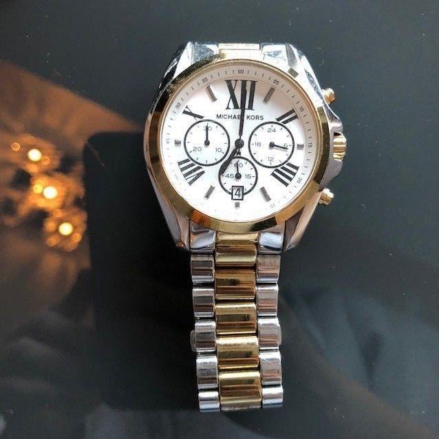 Michael Kors Bradshaw chronograph watch worn on wrist with white dial and two-tone bracelet