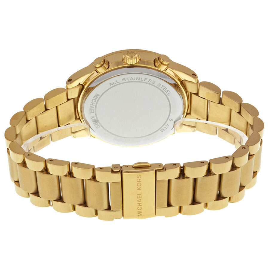 Caseback view of Michael Kors Brinkley watch showing stainless steel case with crystal display, Michael Kors branding, and gold-tone bracelet
