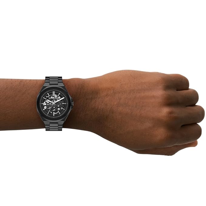 Michael Kors Callum watch worn on wrist showing skeleton dial and black bracelet