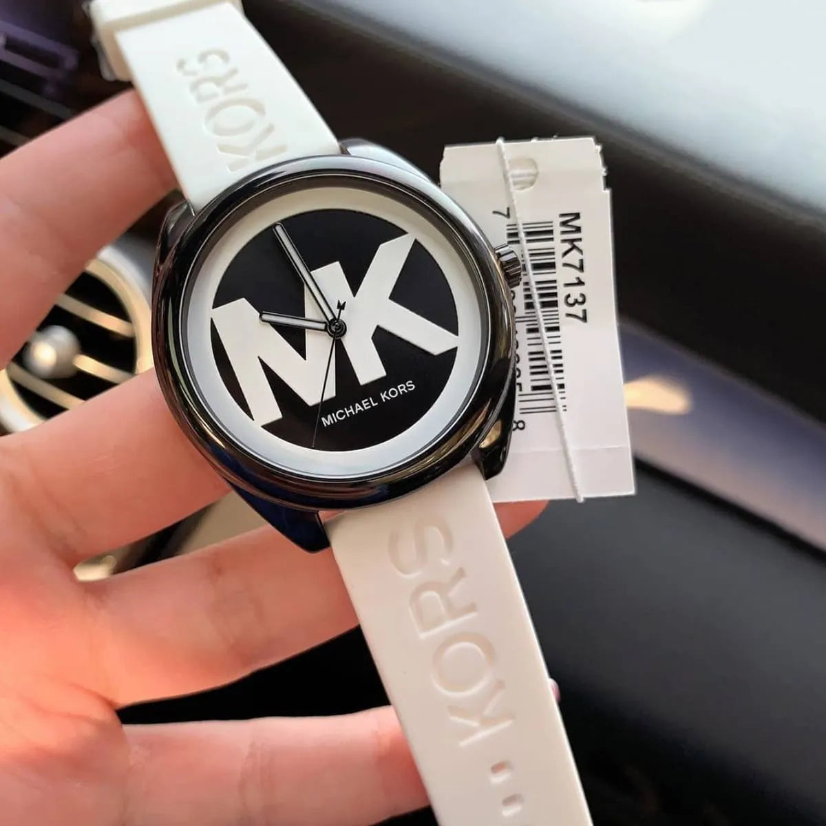 Michael Kors Janelle MK7137 watch worn on wrist with white rubber strap and black and white dial