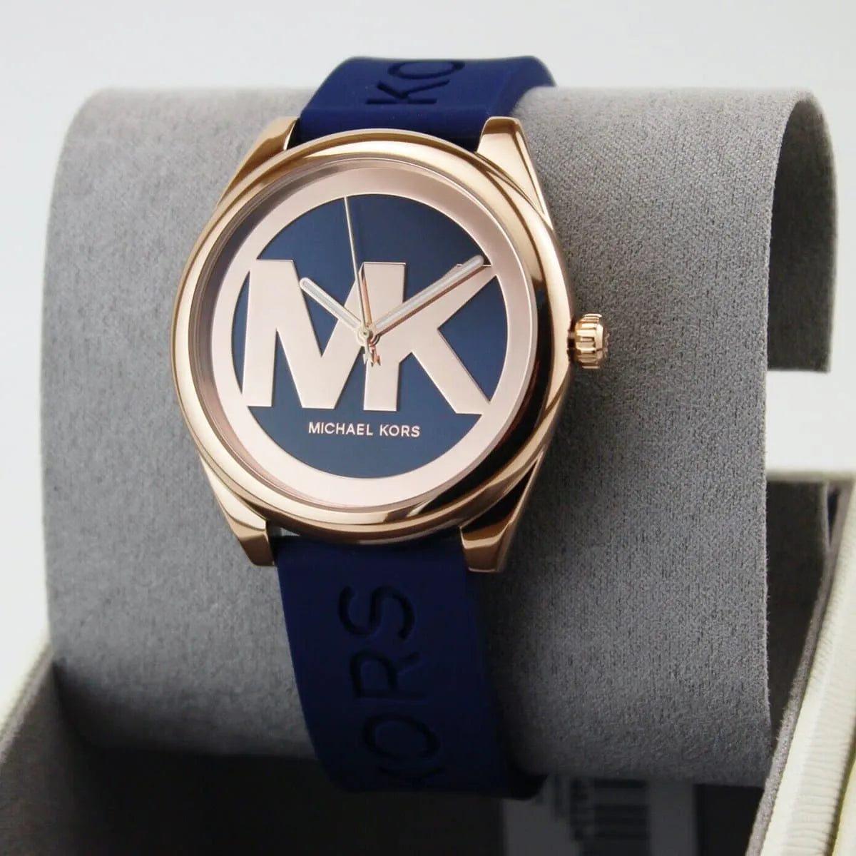 Michael Kors Janelle watch displayed on stand showing three-hand dial and rose gold case