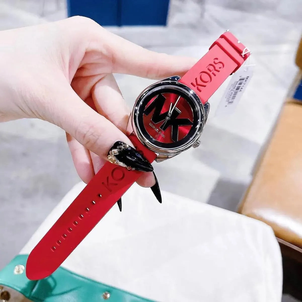 Michael Kors Janelle watch on wrist displaying red dial with three hands