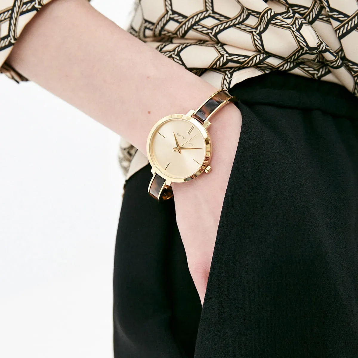 Michael Kors Jaryn women's watch worn on wrist with gold dial and strap