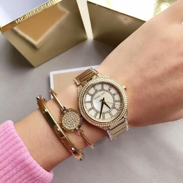 Michael Kors Kerry watch on wrist with crystal-set bezel and bracelet styled with accessories