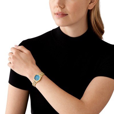 Michael Kors Lexington MK4813 petite watch worn on wrist showing blue dial and gold bracelet