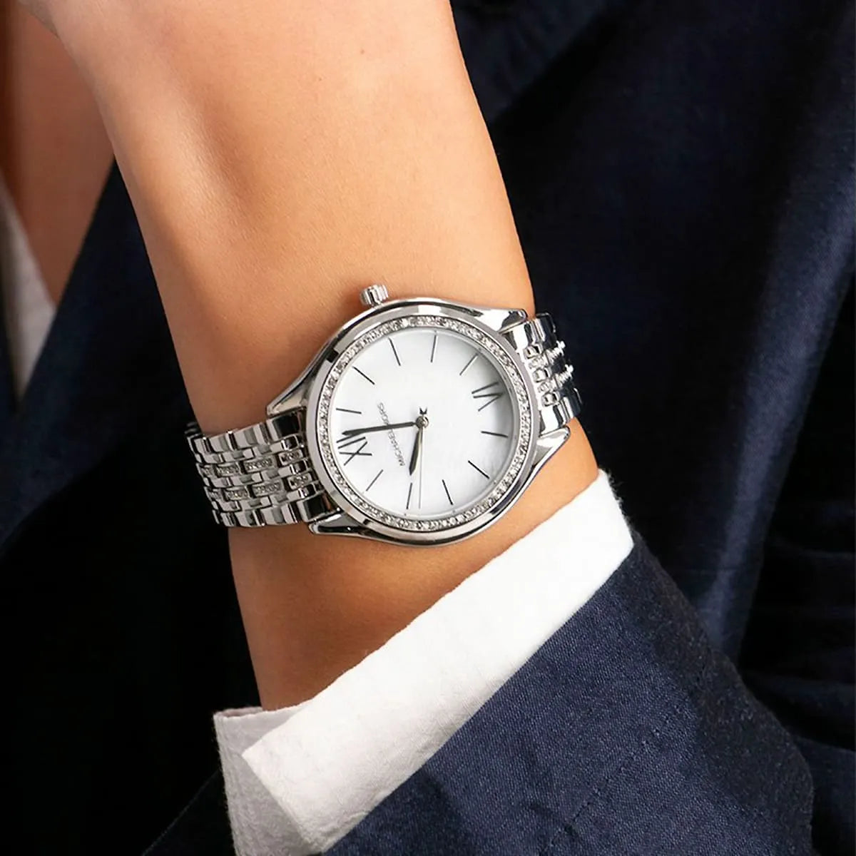 Michael Kors Mindy women's watch on wrist with silver bracelet and white face