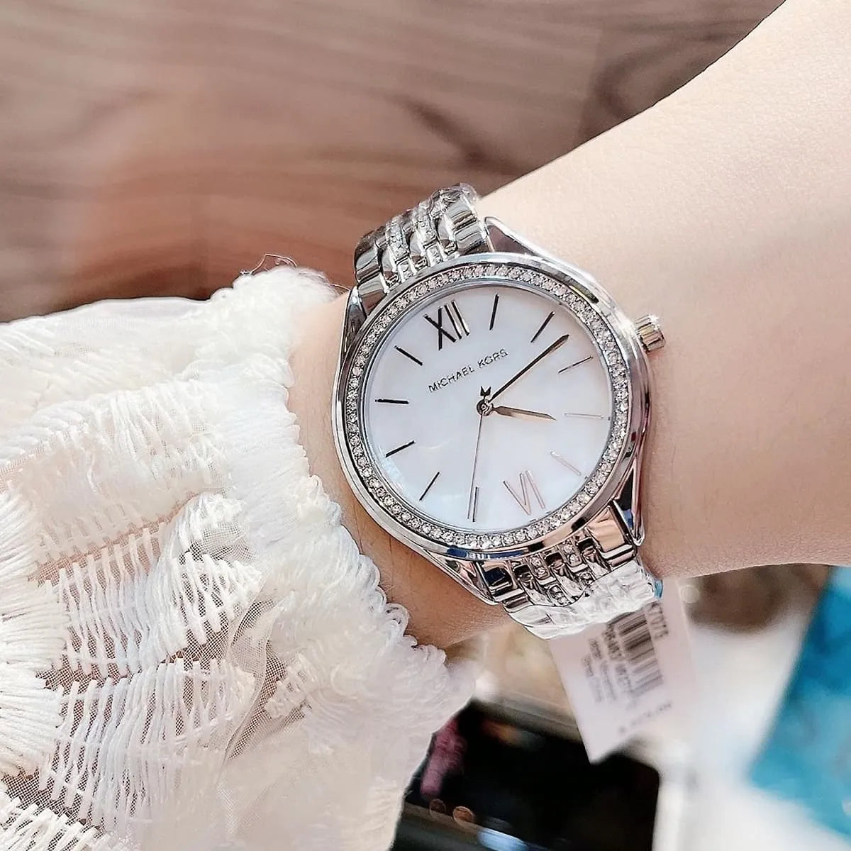 Michael Kors Mindy MK7075 watch on wrist with white dial and crystal bezel detail