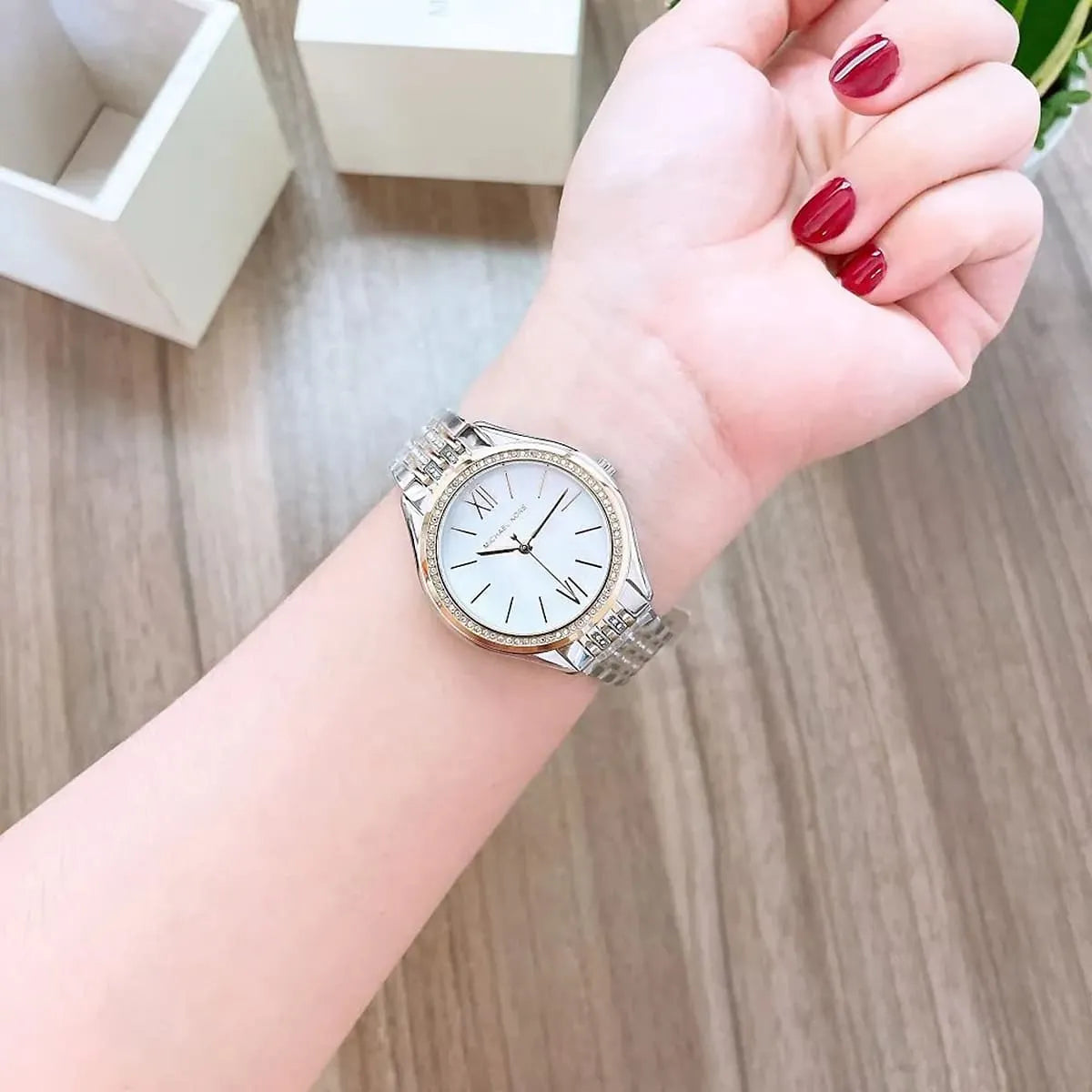 Michael Kors Mindy watch on wrist displaying clean white dial and two-tone band