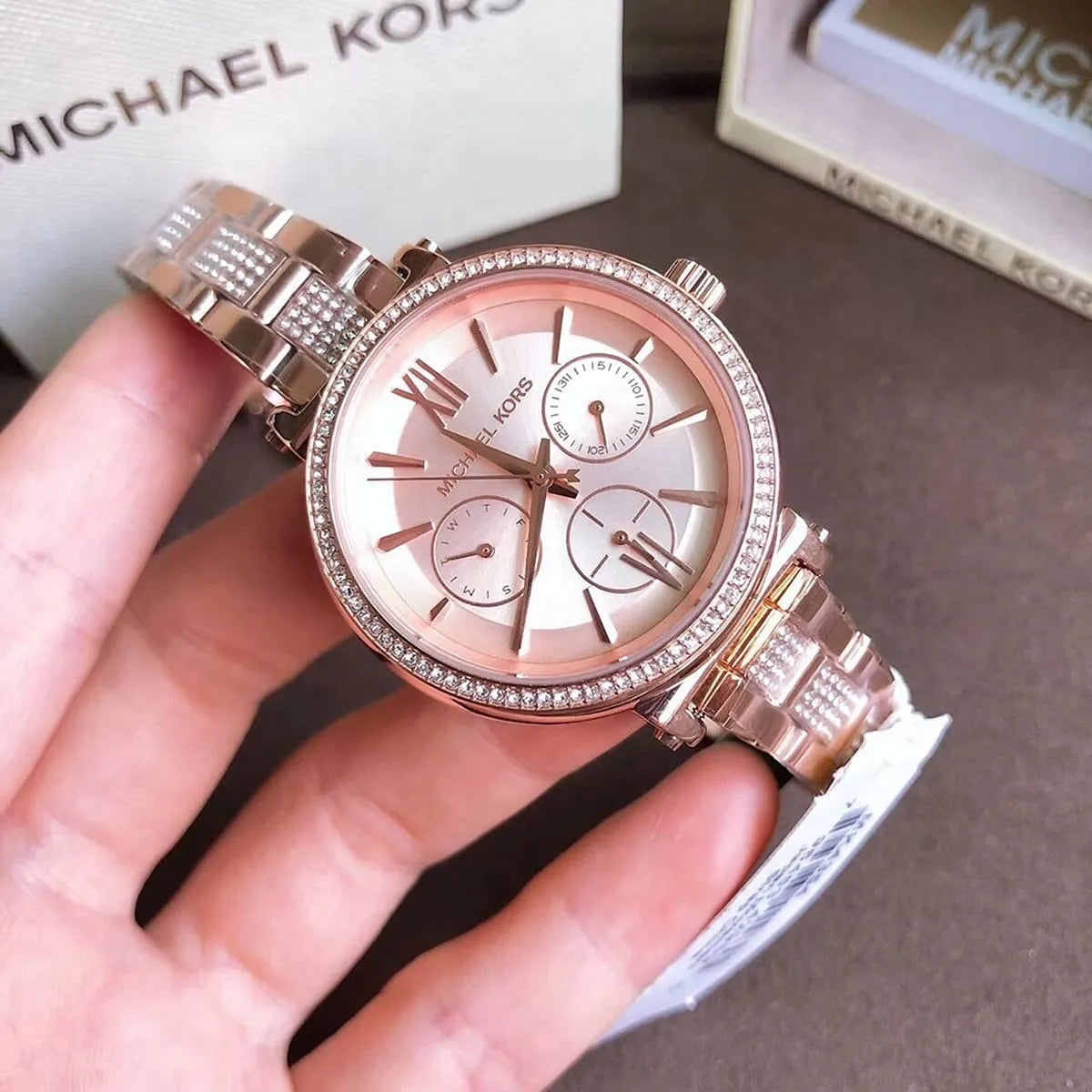 Michael Kors MK4354 Sofie rose gold watch held in hand showing dial and crystal bezel