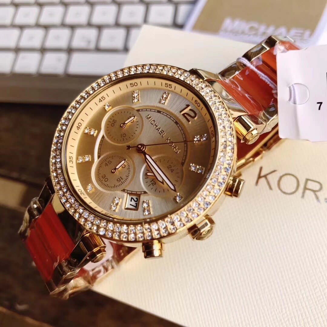Michael Kors Parker ladies watch on wrist with gold case, crystal bezel, and champagne dial