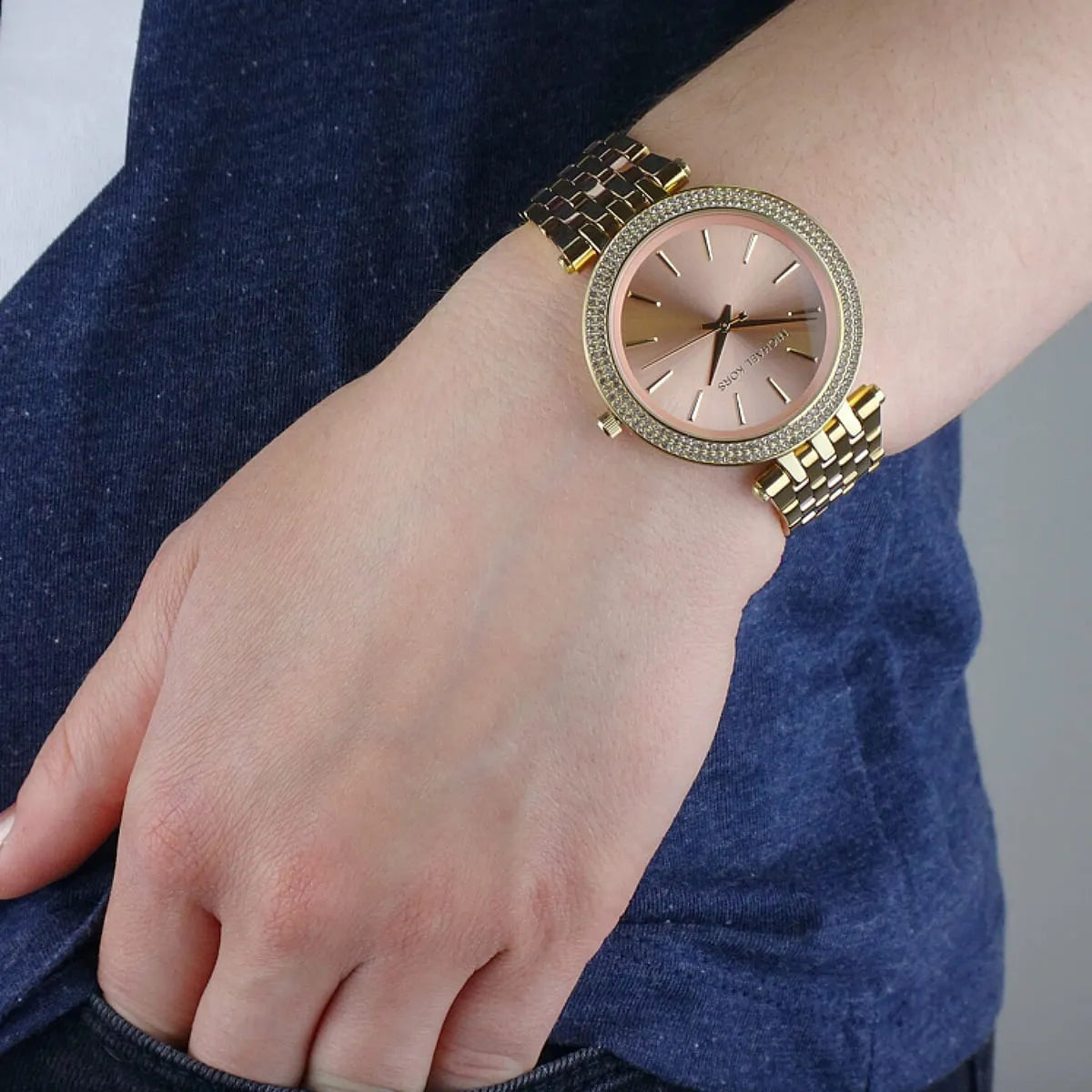 Michael Kors Darci rose gold dial women's watch worn on wrist with crystal bezel