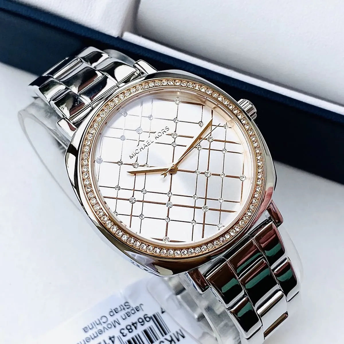 Michael Kors Nia watch detail showing quilted silver dial face and rose gold bezel with crystals