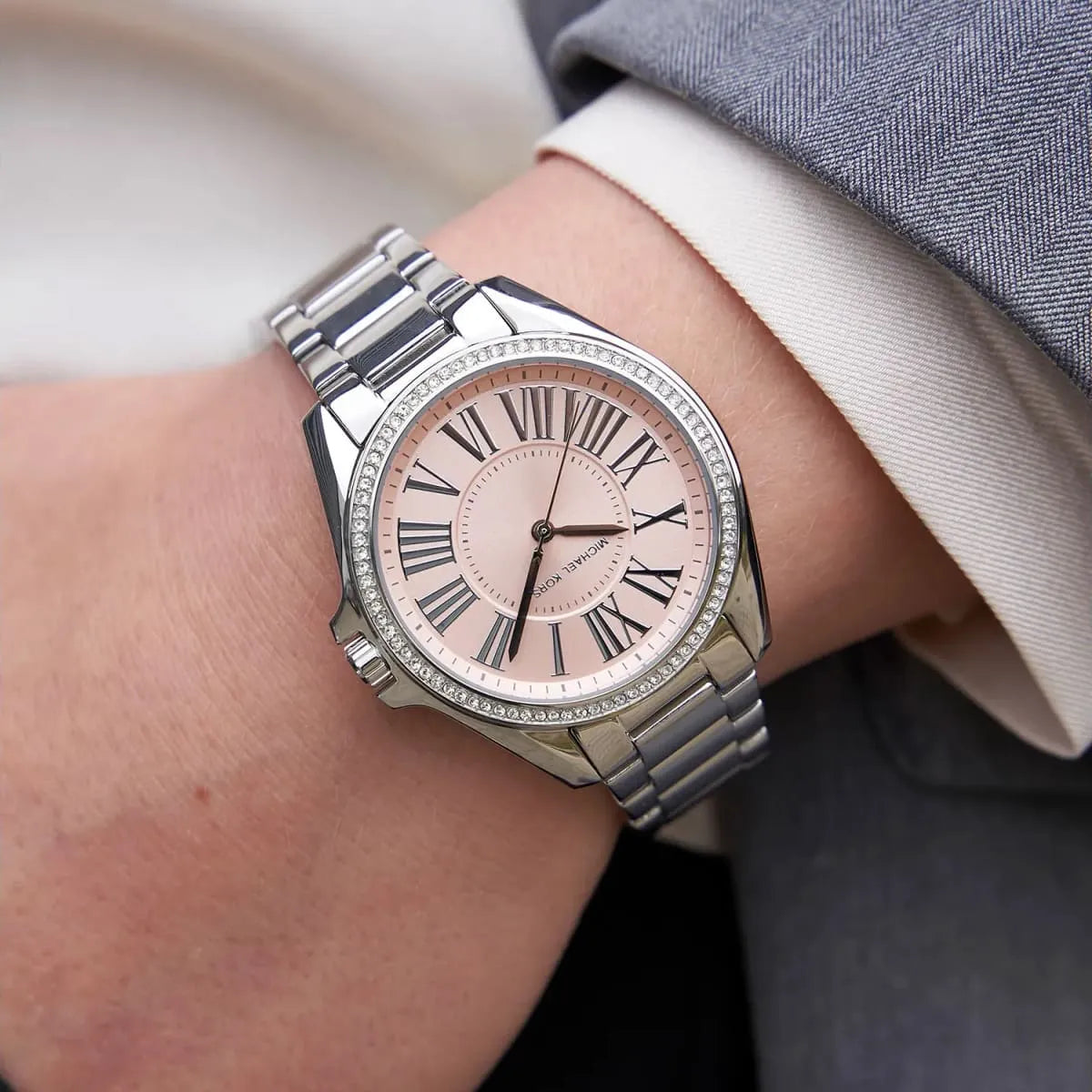 Michael Kors Kacie watch worn on wrist showing pink dial and crystal bezel detail