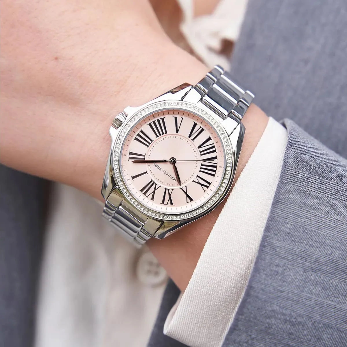 Michael Kors Kacie watch on wrist displaying three hand dial and silver metal bracelet