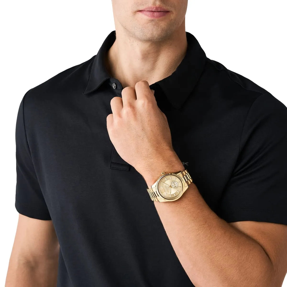 Michael Kors Lexington gold-tone watch worn on wrist with black polo shirt