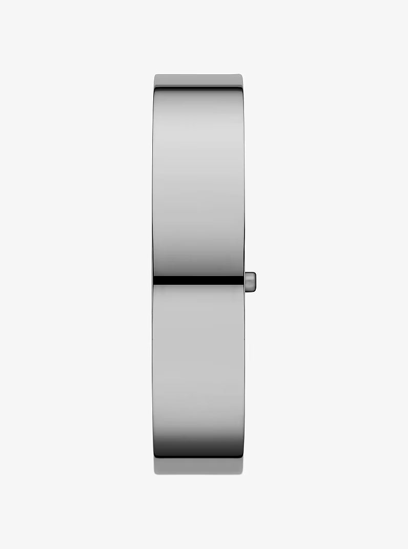 Three-quarter view of Michael Kors silver bangle watch with hinged clasp closure