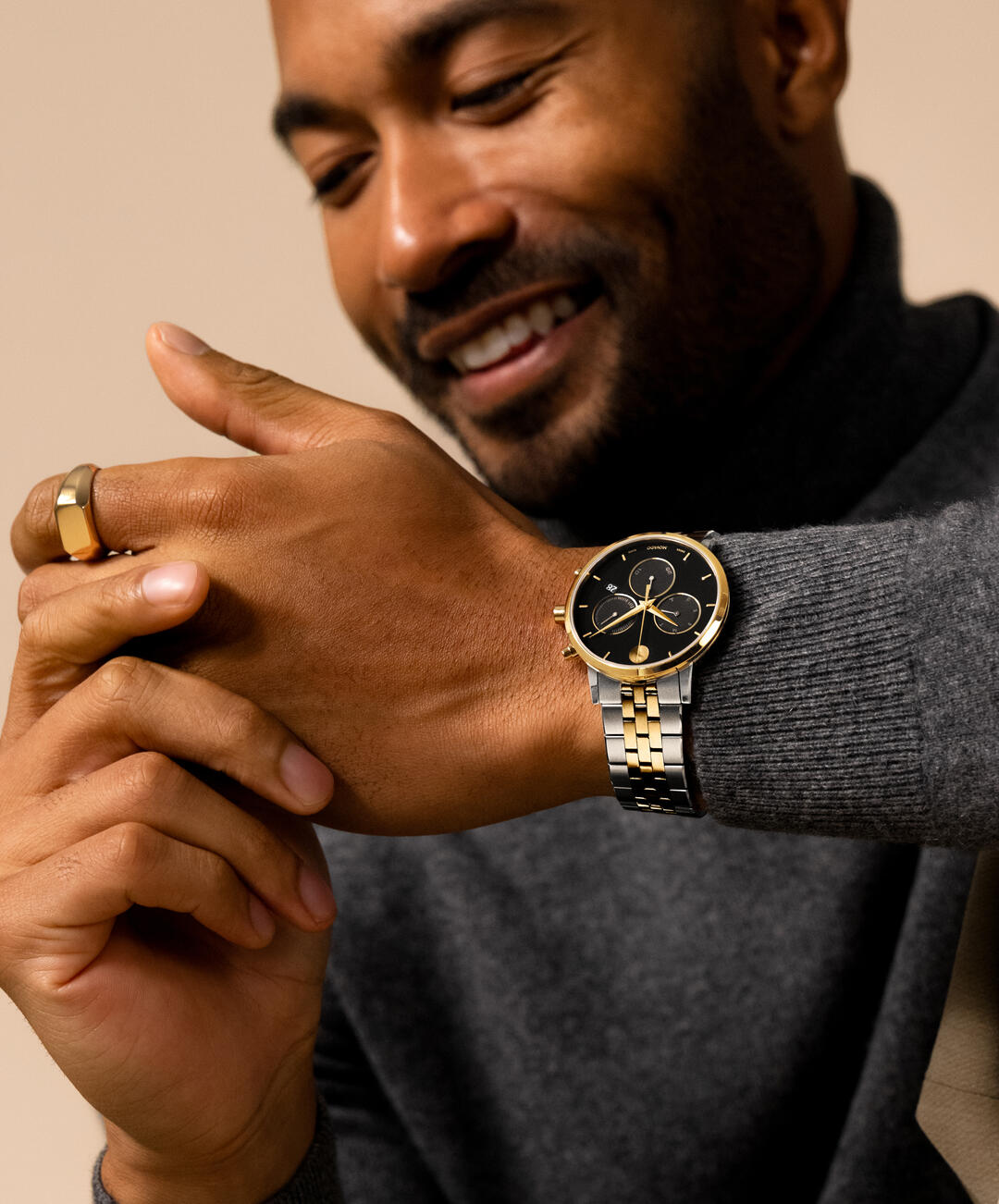 Movado 0607777 chronograph watch worn on wrist showing black dial with gold subdials and mixed metal band