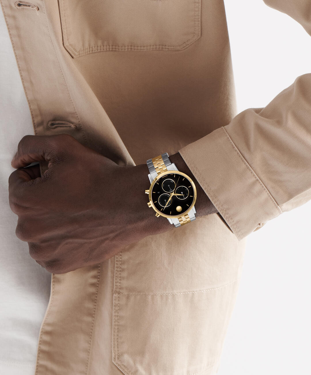 Movado 0607777 chronograph worn on wrist showing black dial and mixed metal bracelet against beige clothing