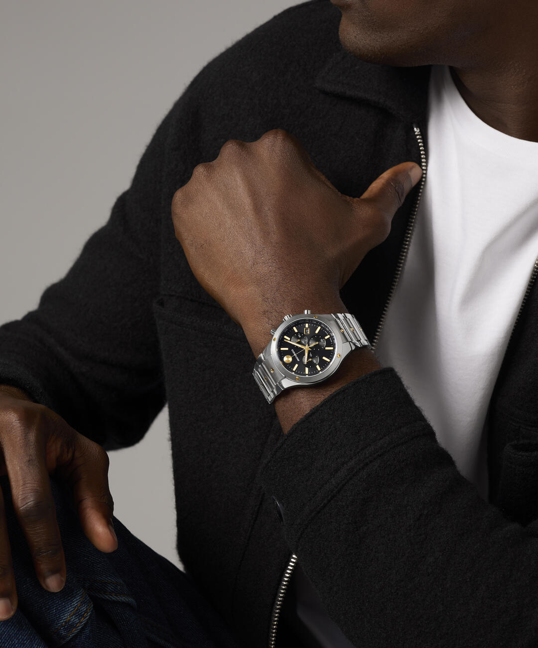 Movado chronograph watch worn on wrist with black dial and mixed metal band