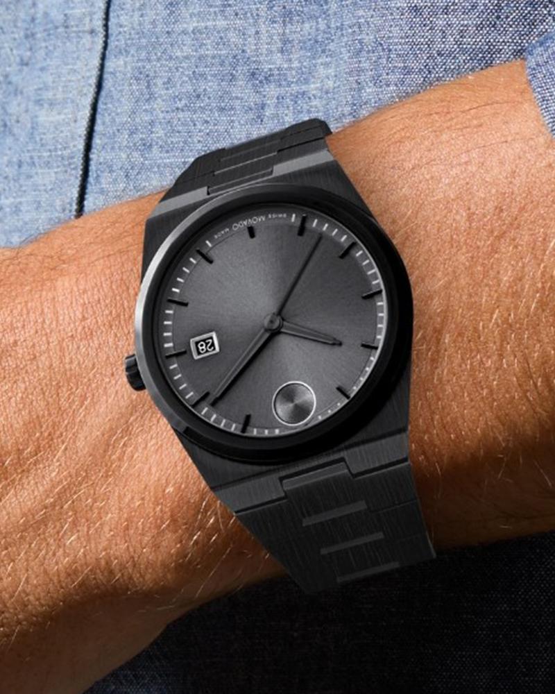 Movado BOLD Quest men's watch worn on wrist showing grey dial and black bracelet