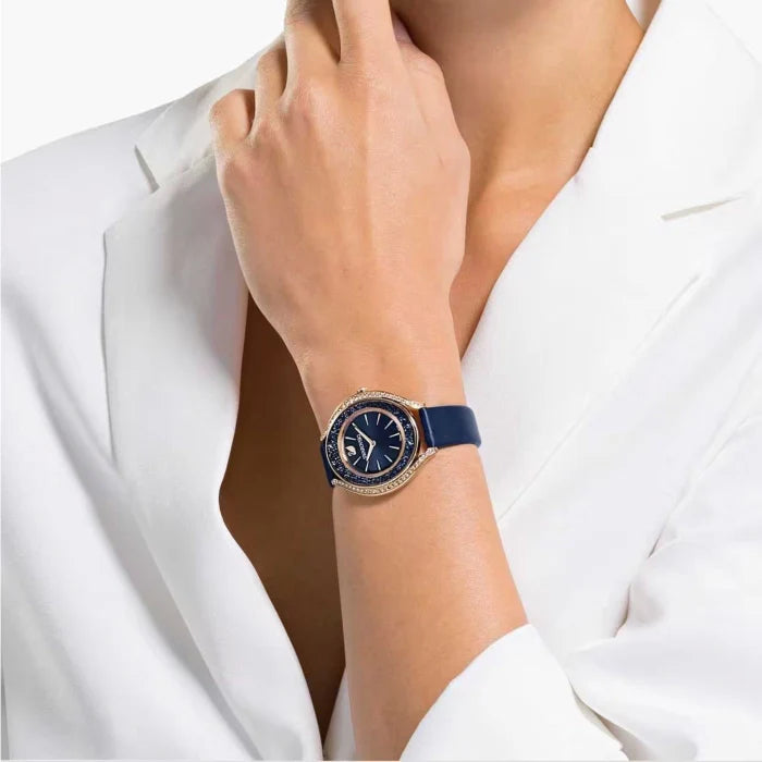 Crystalline Aura rose gold watch on wrist with navy strap