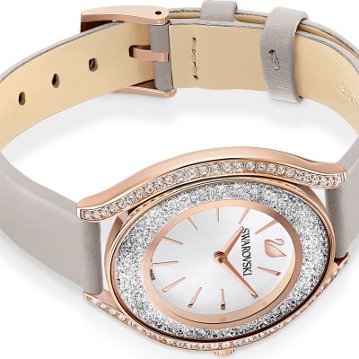 Swarovski Crystalline Aura watch worn on wrist, showing crystal case and white dial with grey strap