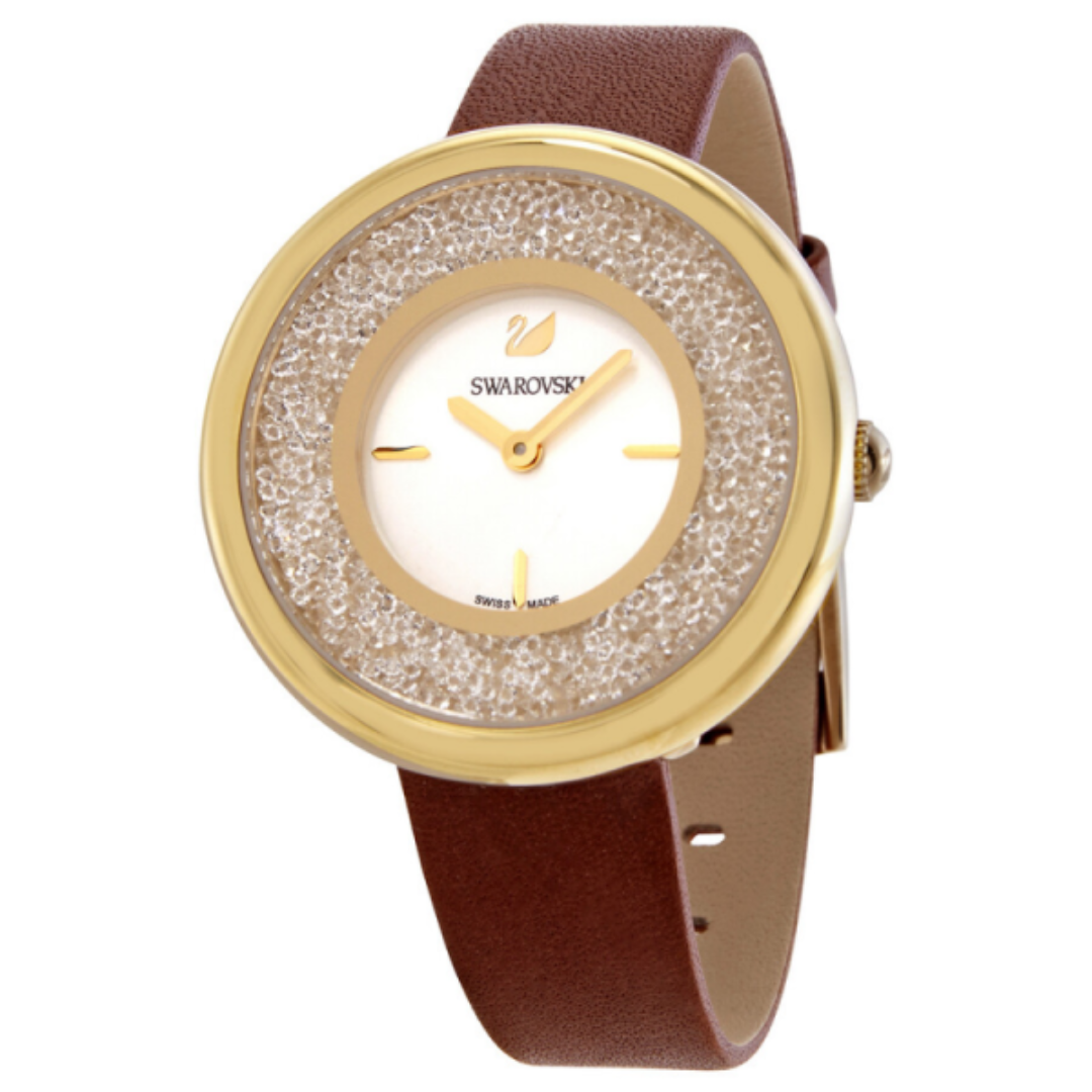 Swarovski Crystalline Pure watch with white dial, gold case, crystal-set bezel, and brown leather strap