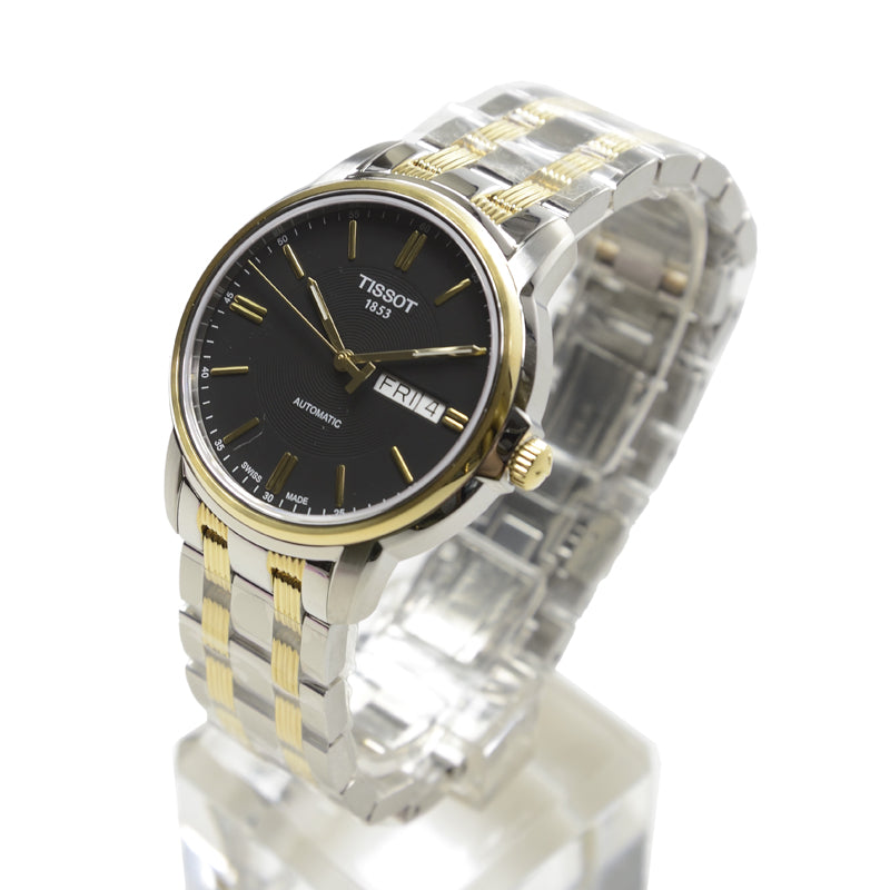Tissot Automatics two-tone watch displayed on wrist with black dial and day-date window